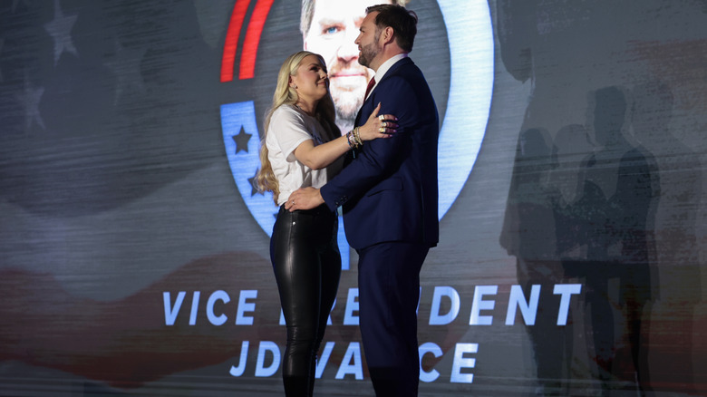 Erika Kirk wearing leather pants and hugging JD Vance at a TPUSA event