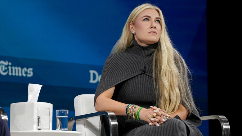 Erika Kirk looking up and clasping her hands while on stage