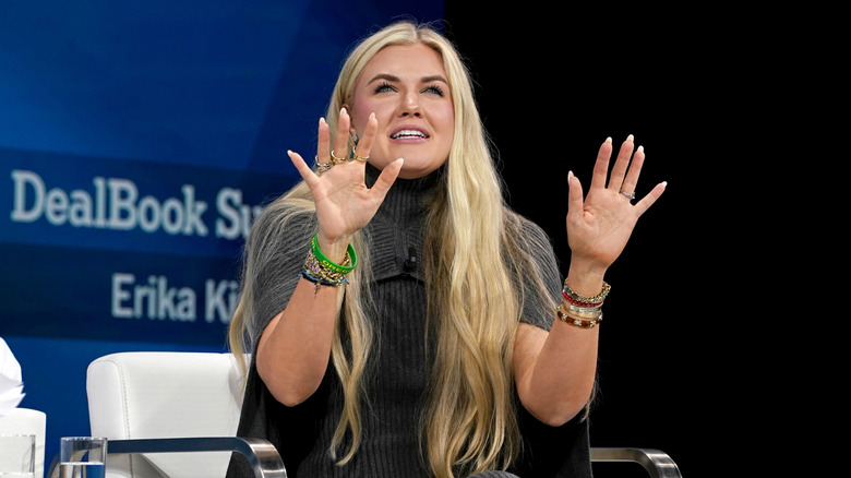 Erika Kirk at DealBook summit wearing gray turtleneck dress and lots of bracelets