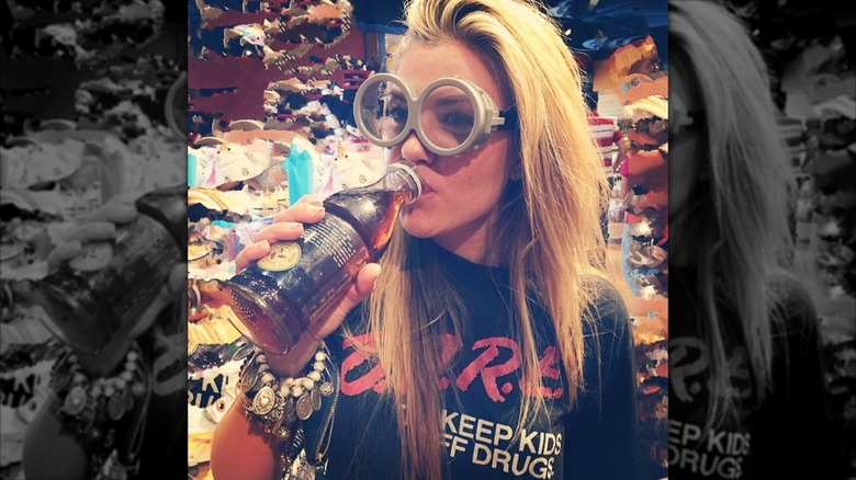 Erika Kirk drinking a soda and wearing minion glasses in 2014
