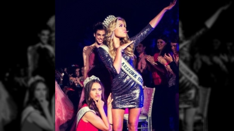 Erika Kirk posing as Arizona beauty queen wearing a sash and crown with other beauty queens