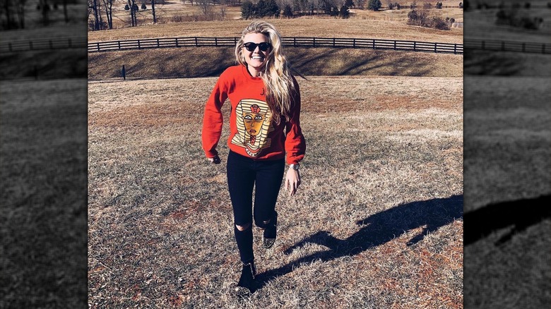 Erika Kirk smiling and running through a field