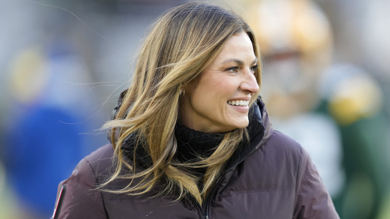 Erin Andrews smiling while wearing a brown jacket