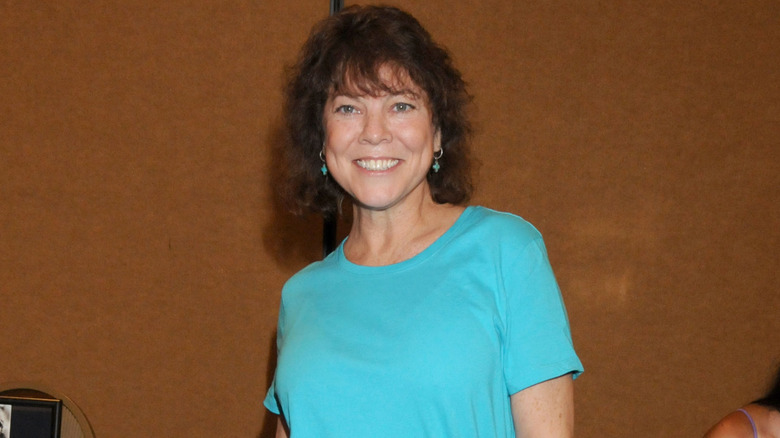 Erin Moran dark curly bob, light blue t-shirt