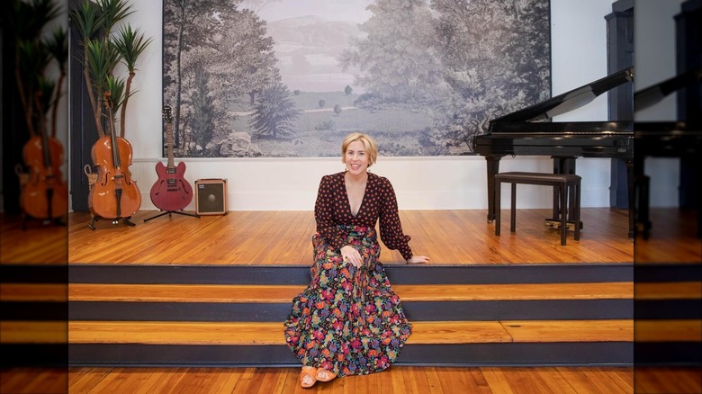 Erin Napier sitting in front of painting and instruments
