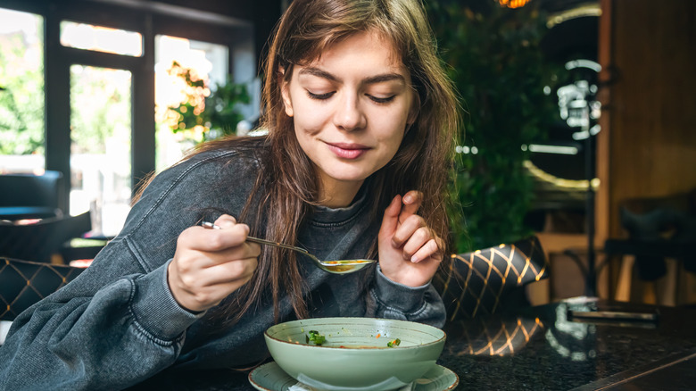 woman eating soup with spoon
