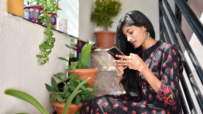 woman sitting on stairs texting
