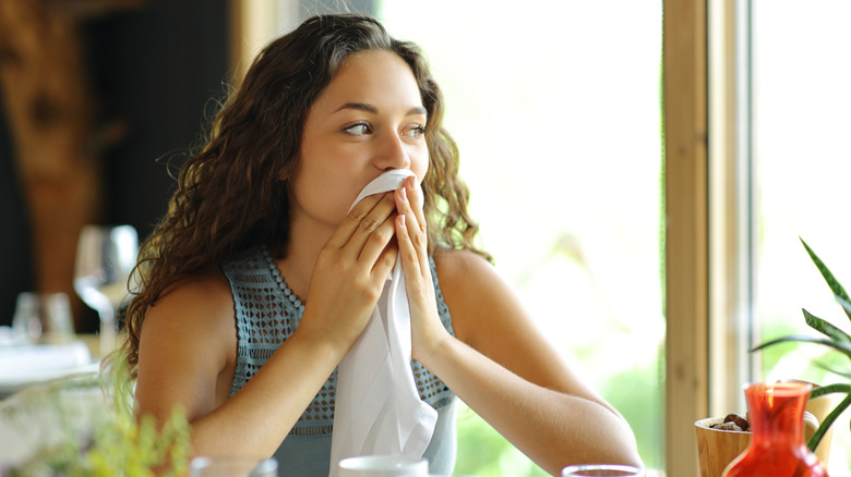 woman wiping mouth with napkin
