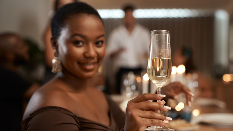 Woman raising a champagne glass for a toast