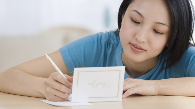 woman writing in a thank you card