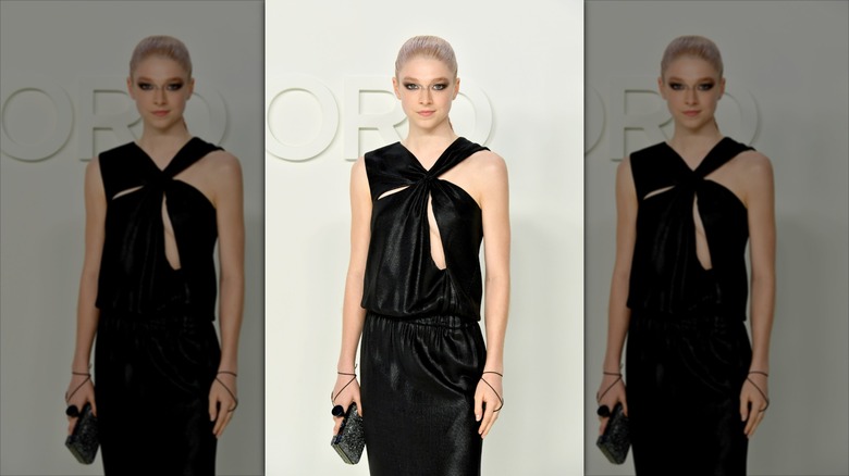 Hunter Schafer posing in a black dress at the Tom Ford AW20 Show in 2020.