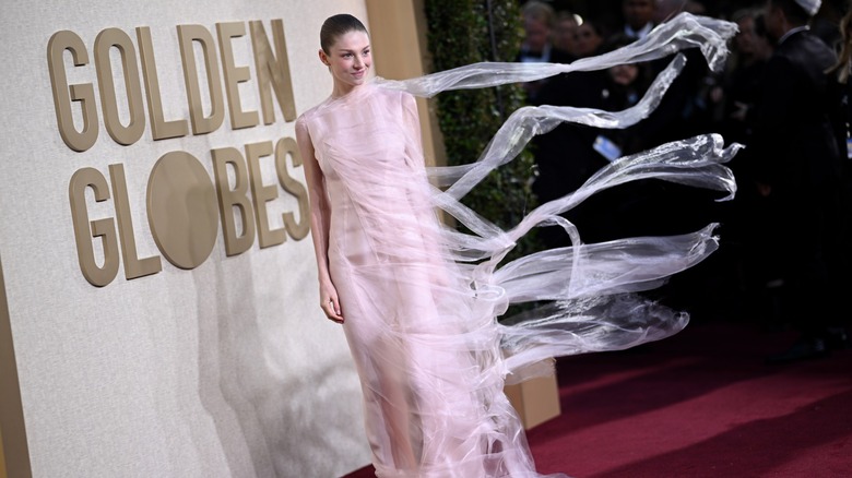 Hunter Schafer at the Golden Globes, her pink dress flowing in the wind