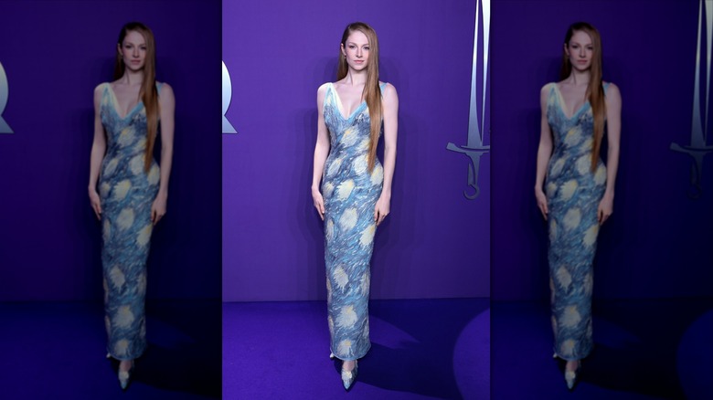 Hunter Schafer against a purple background, wearing a dress that looks like Van Gogh's "Starry Night"