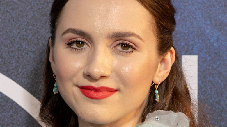 Maude Apatow on red carpet with bold red lip