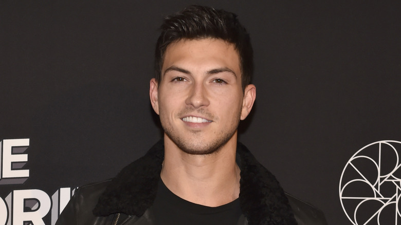 Robert Scott Wilson smiling while posing at an event in a black outfit