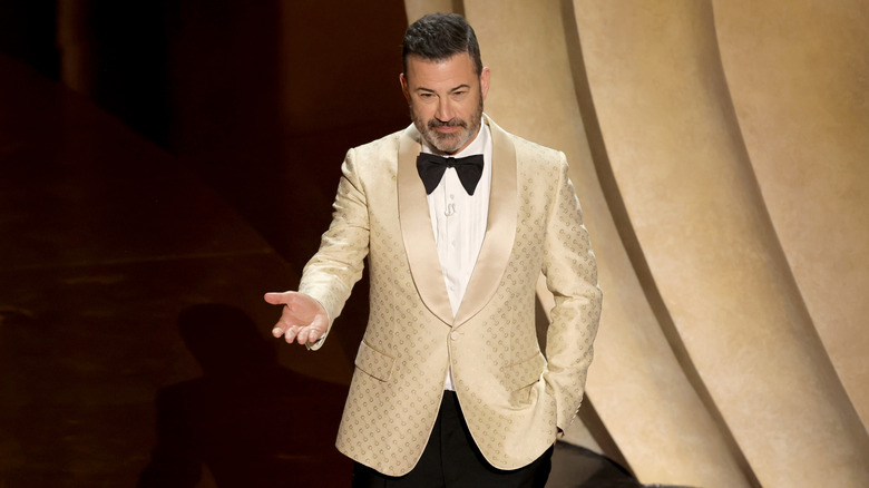 Jimmy Kimmel hosting the Oscars 2024 in a gold jacket and bow tie