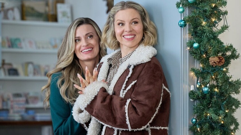 Brooke D'Orsay and Ali Liebert smiling in a room with Christmas decorations