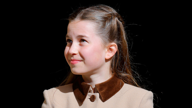 Princess Charlotte smiling in a brown and beige dress