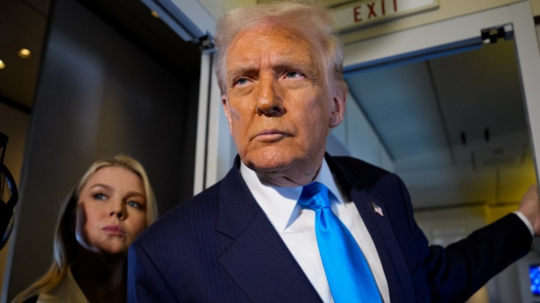 Donald Trump looking angry in a navy suit with a blue tie