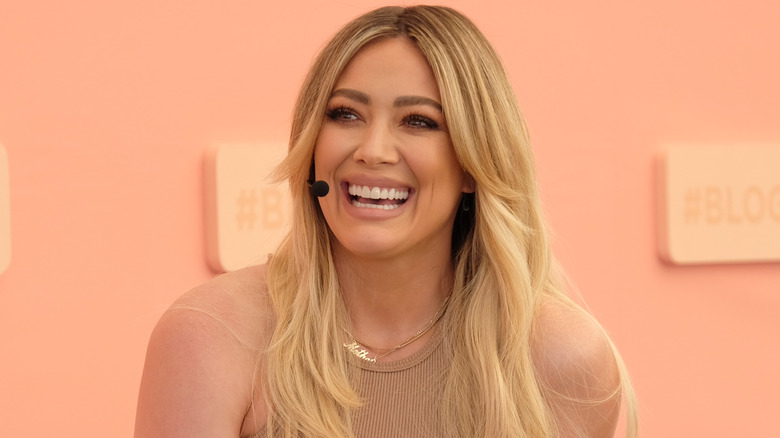 Hilary Duff laughing onstage at an event