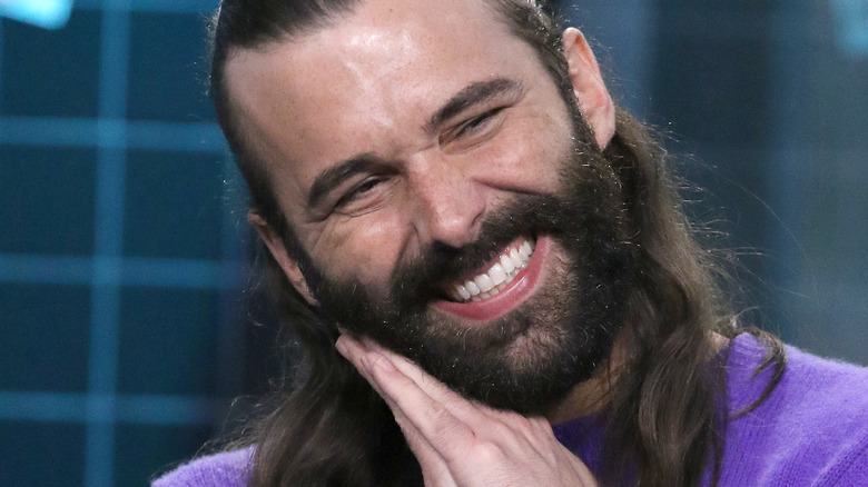 Jonathan Van Ness smiling big with clasped hands