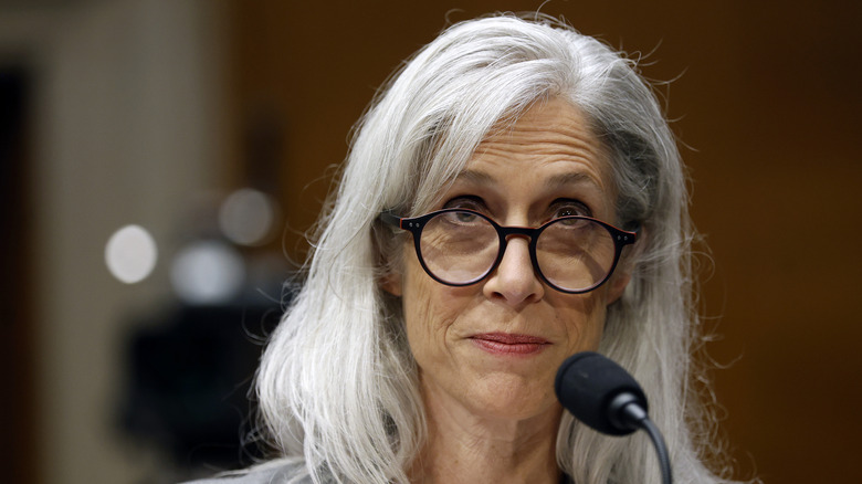 Susan Monarez with long gray hair and glasses speaking into a microphone