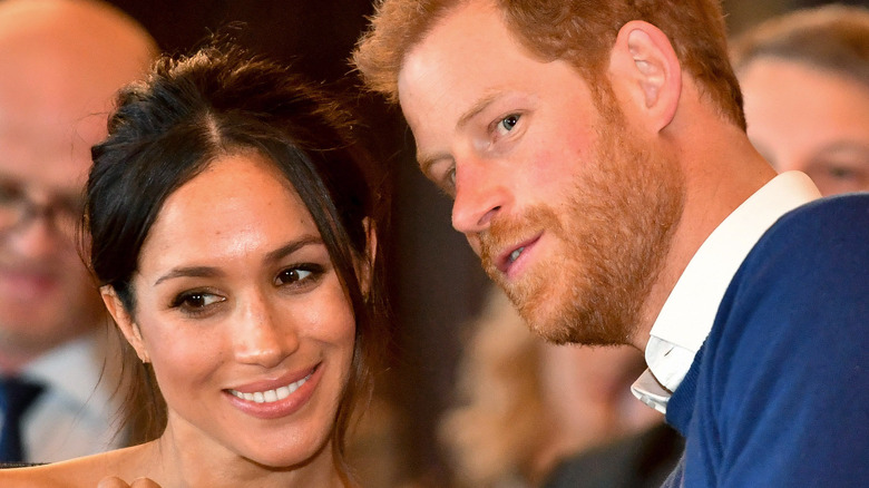 Harry and Meghan talking at event 