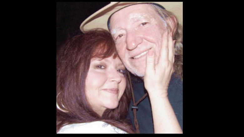 Renee Butts putting her hand on Willie Nelson's face