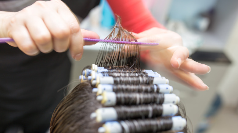 Hairstylist giving client a perm