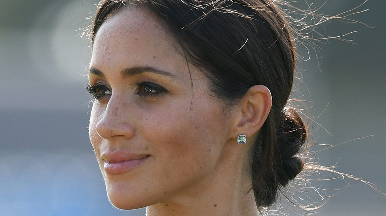 Meghan Markle smiling, side profile. 