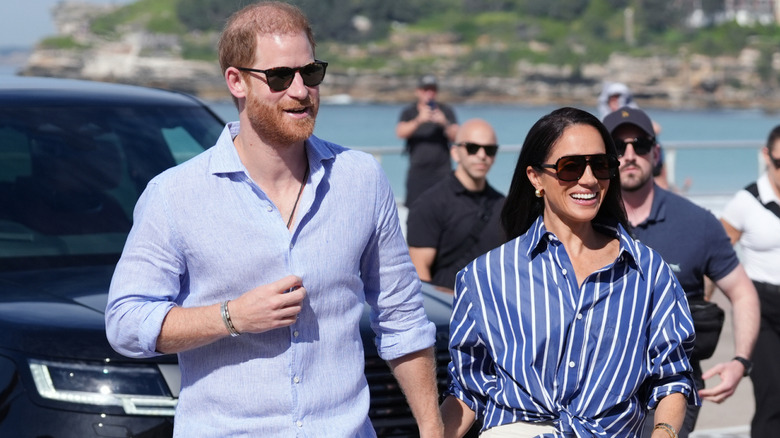 A smiling Prince Harry and Meghan Markle holding hands