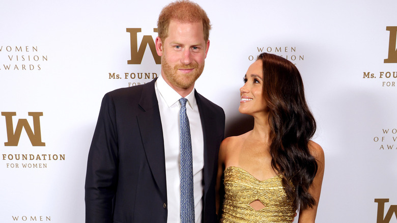 Meghan Markle looking adoringly at a smiling Prince Harry