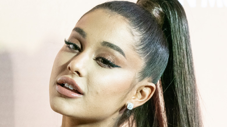 ariana grande with a high ponytail looking to the side