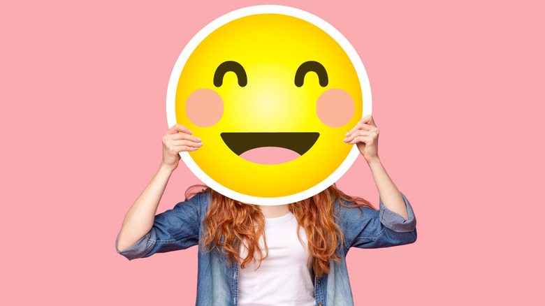 Woman holding emoji cutout