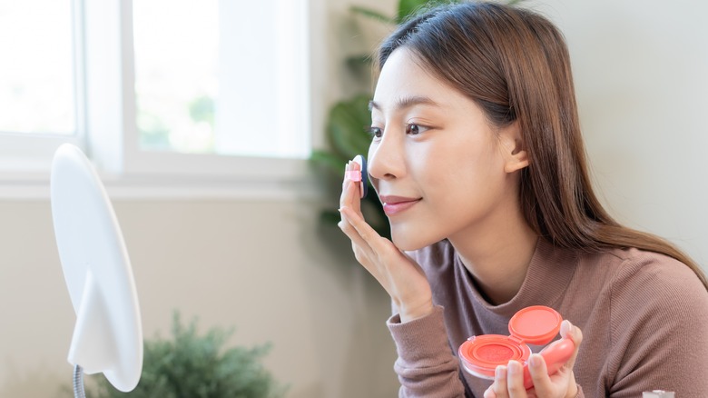 A woman applying blush