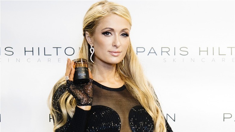 Paris Hilton holding ProD.N.A. product