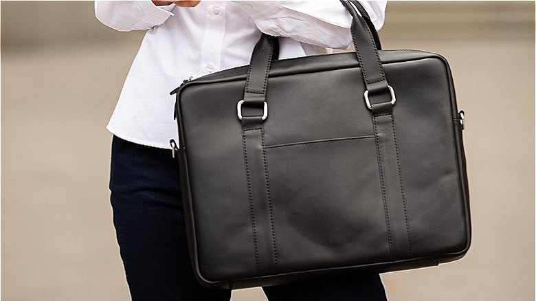Woman carries a black briefcase