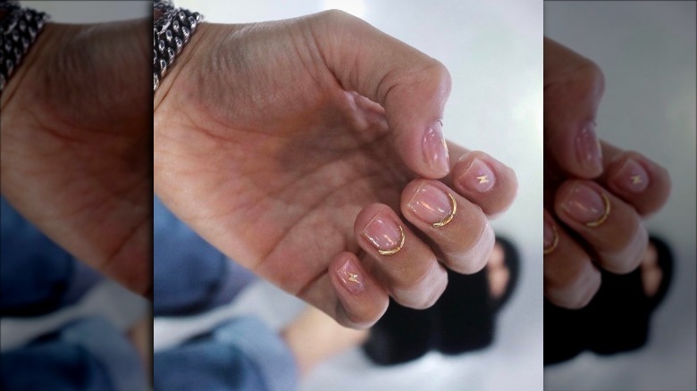 Closeup of gold Korean cuticle nails manicure.