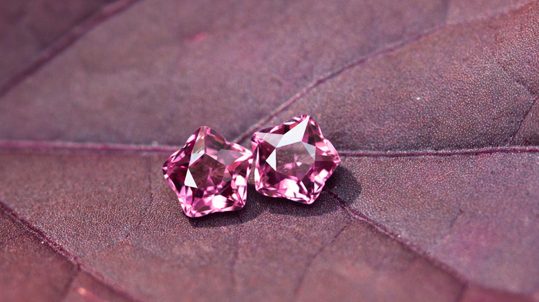 Two pink tourmaline gemstones on a pink leaf