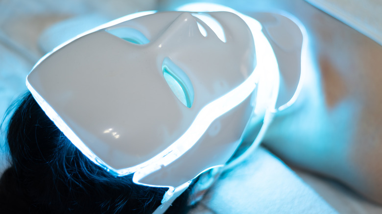 Woman receiving blue light frequencies in an LED facial