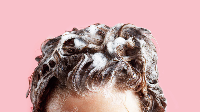 A woman shampooing her hair 