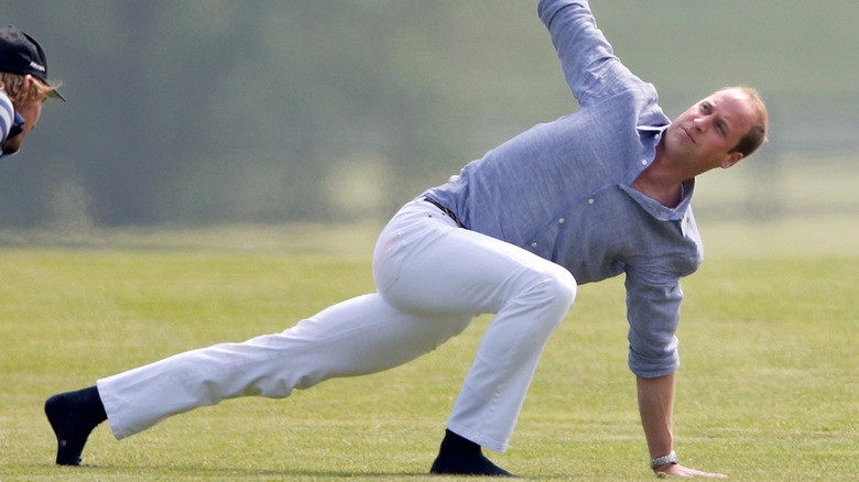 Prince William doing a yoga pose in his jeans.