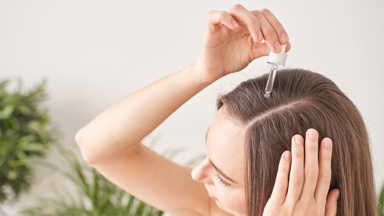 Woman applying product to scalp