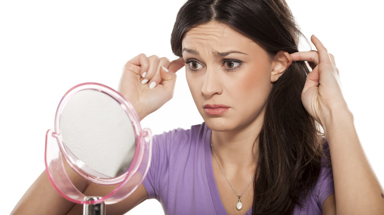 Woman examining her ears