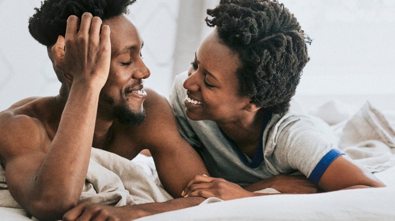 couple smiling while in bed