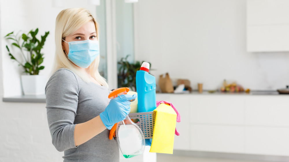 Woman holding cleaning supplies