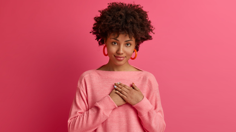 A woman with her hand on her heart