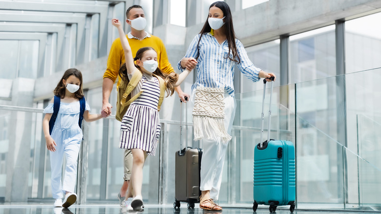 family traveling wearing masks