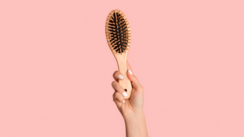 Wooden hair brush with pink background