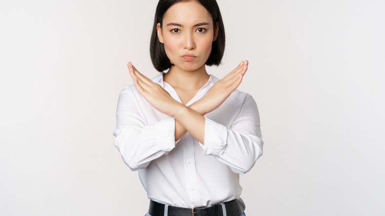 Woman crosses arms in an X